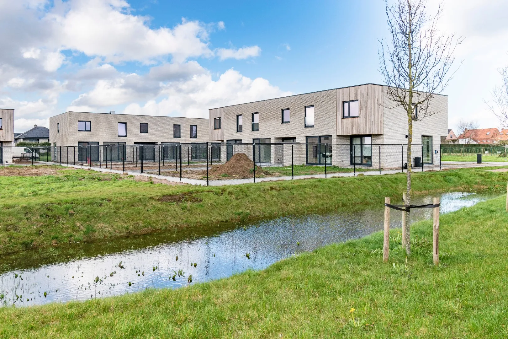 Achterzijde van de woningen in Mirrepadde met tuinen langs een gracht